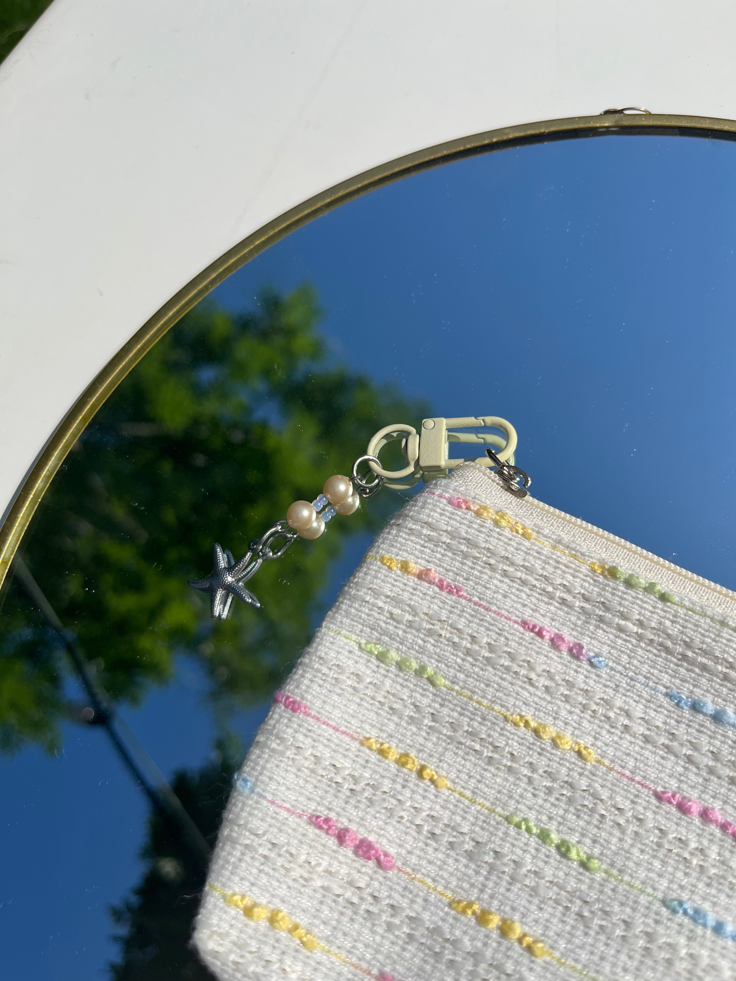 beige toilettas met zeester sleutelhanger