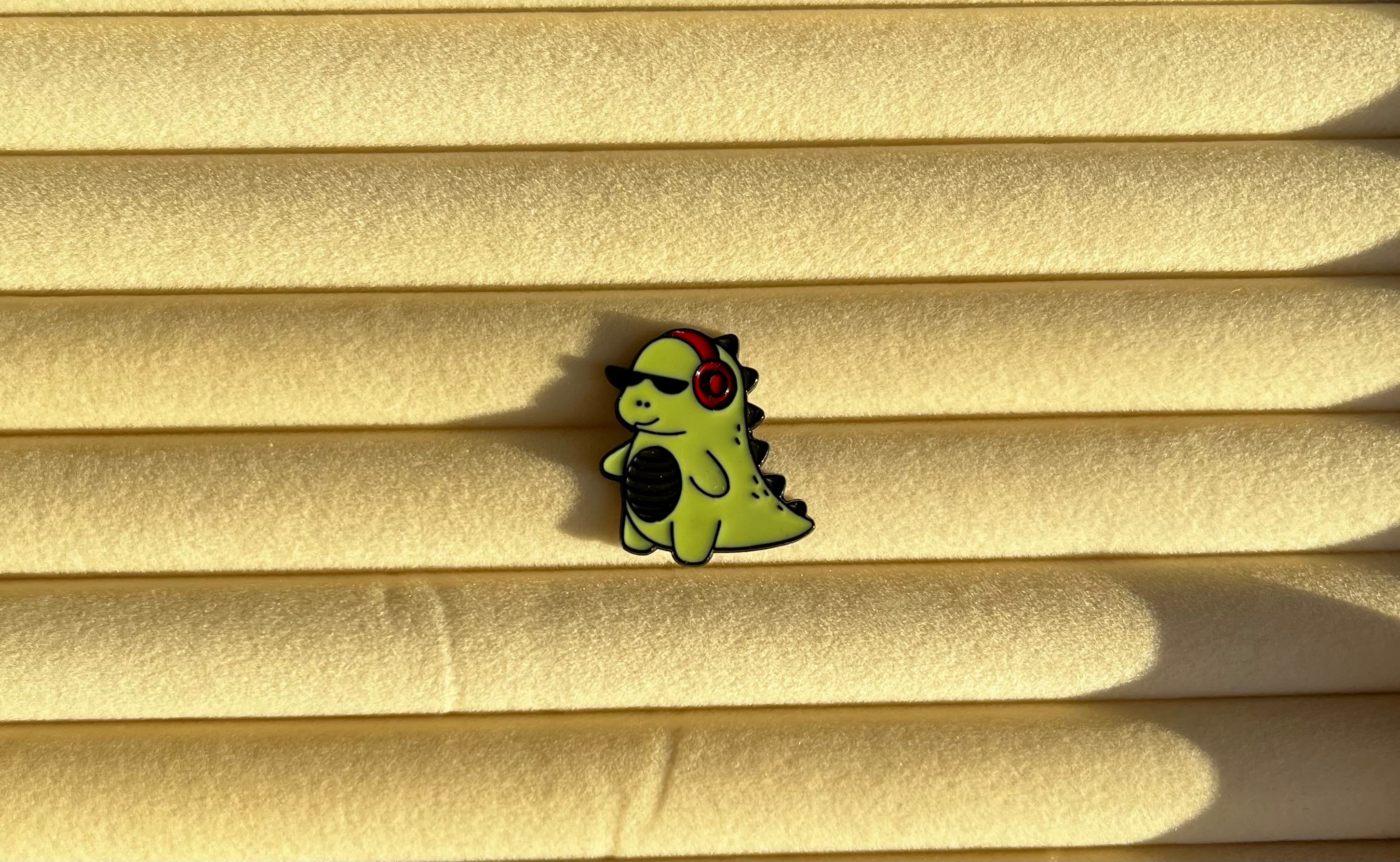 pin groene dino met koptelefoon