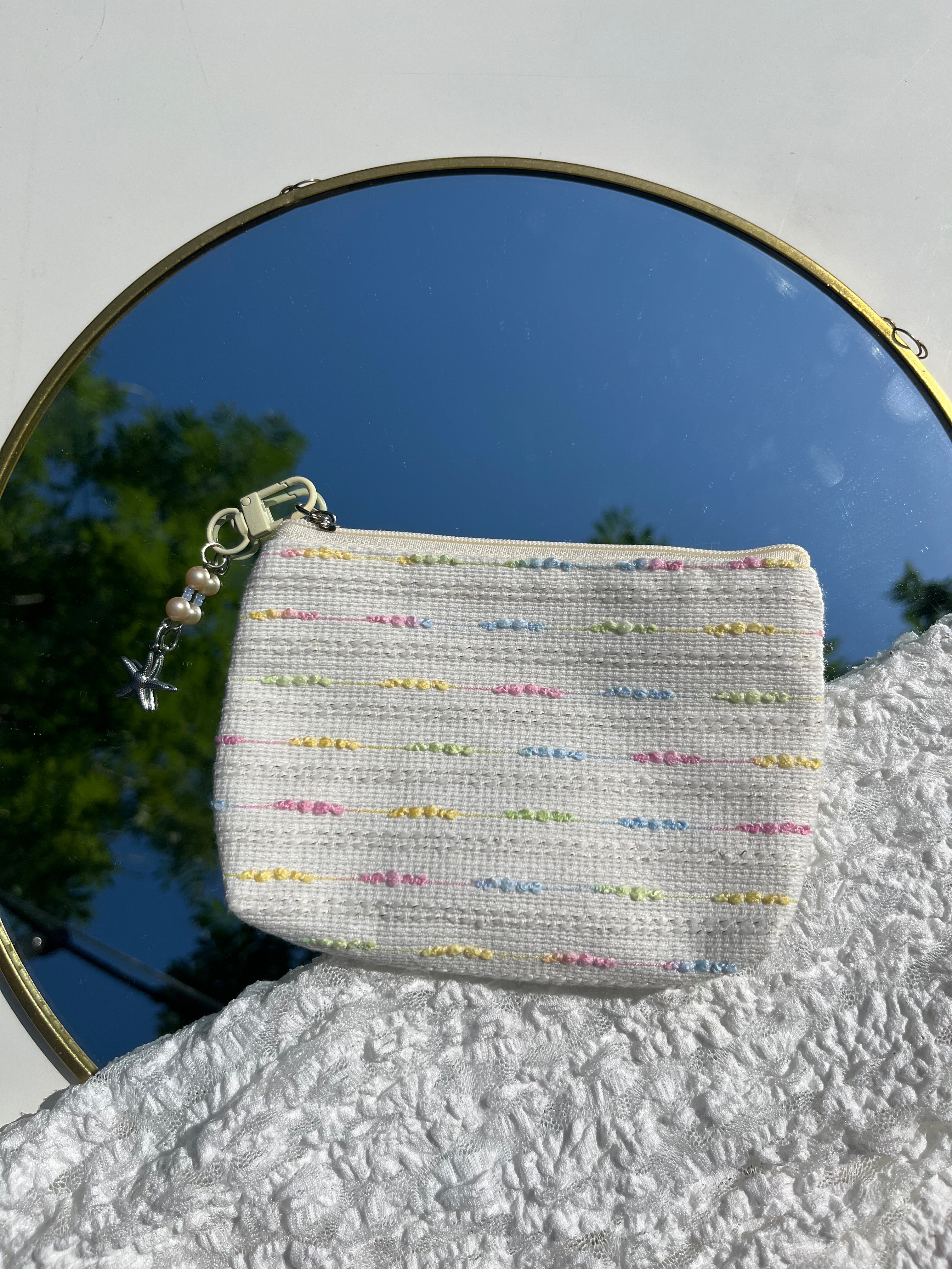 beige toilettas met zeester sleutelhanger